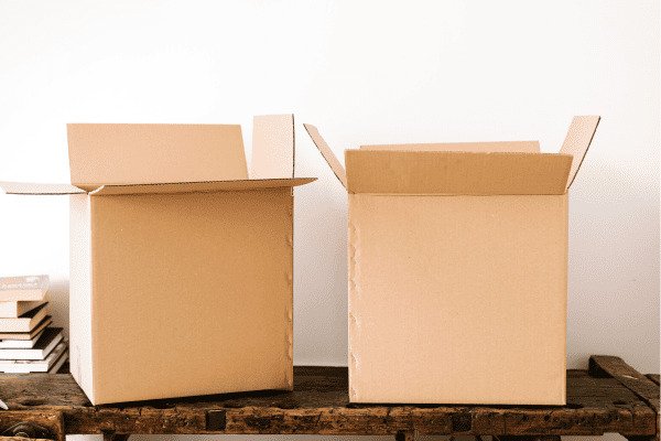 50 Itens para Destralhar da Sua Casa Hoje Mesmo -Duas caixas de papelão abertas em cima de uma mesa