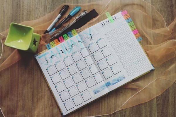 Calendário, Planner ou Bullet Journal Descubra o melhor para você-Planner aberto no mes de janeiro e canetas